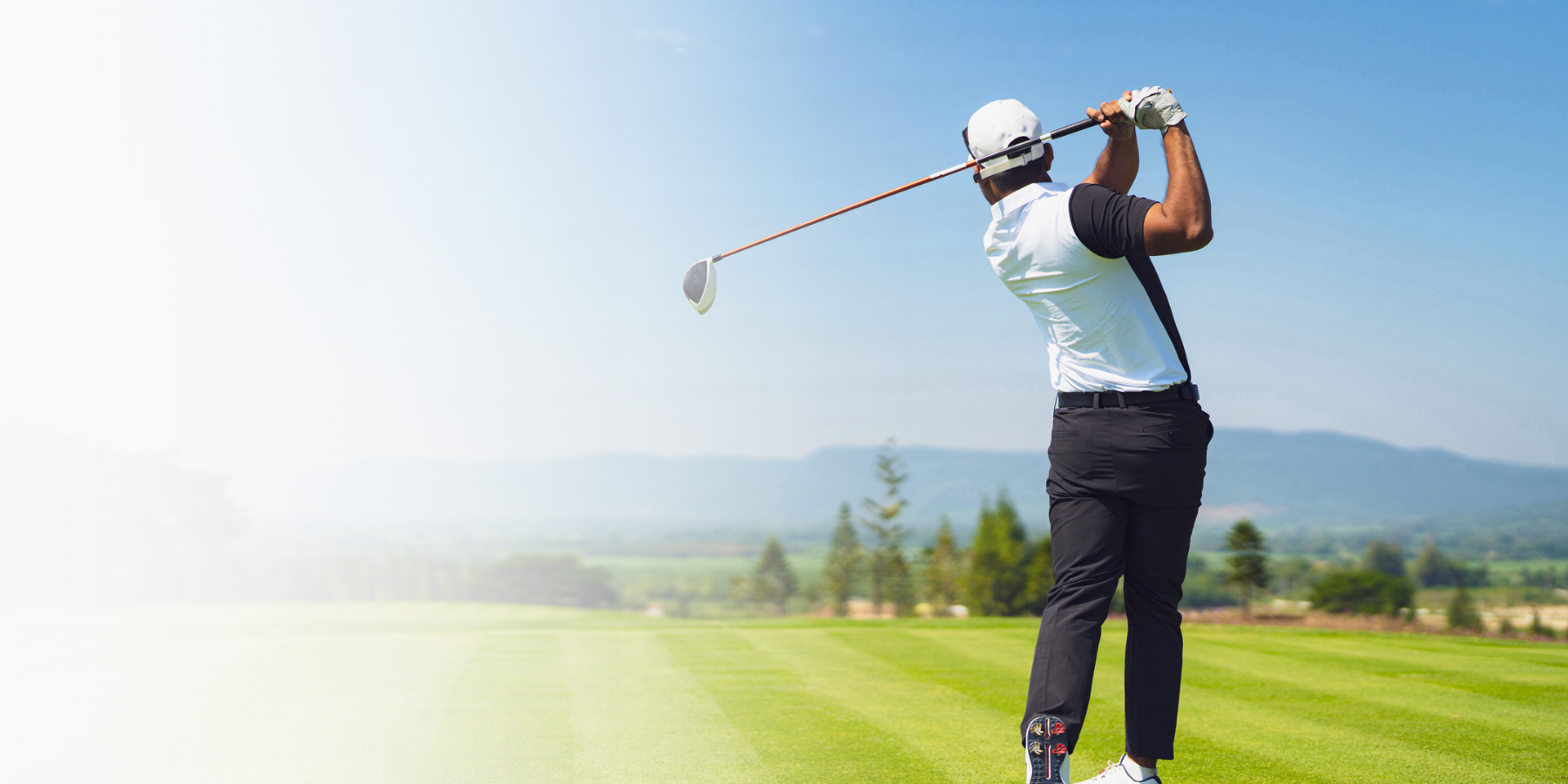 white gradient over a man golfing on a golf course in the summer